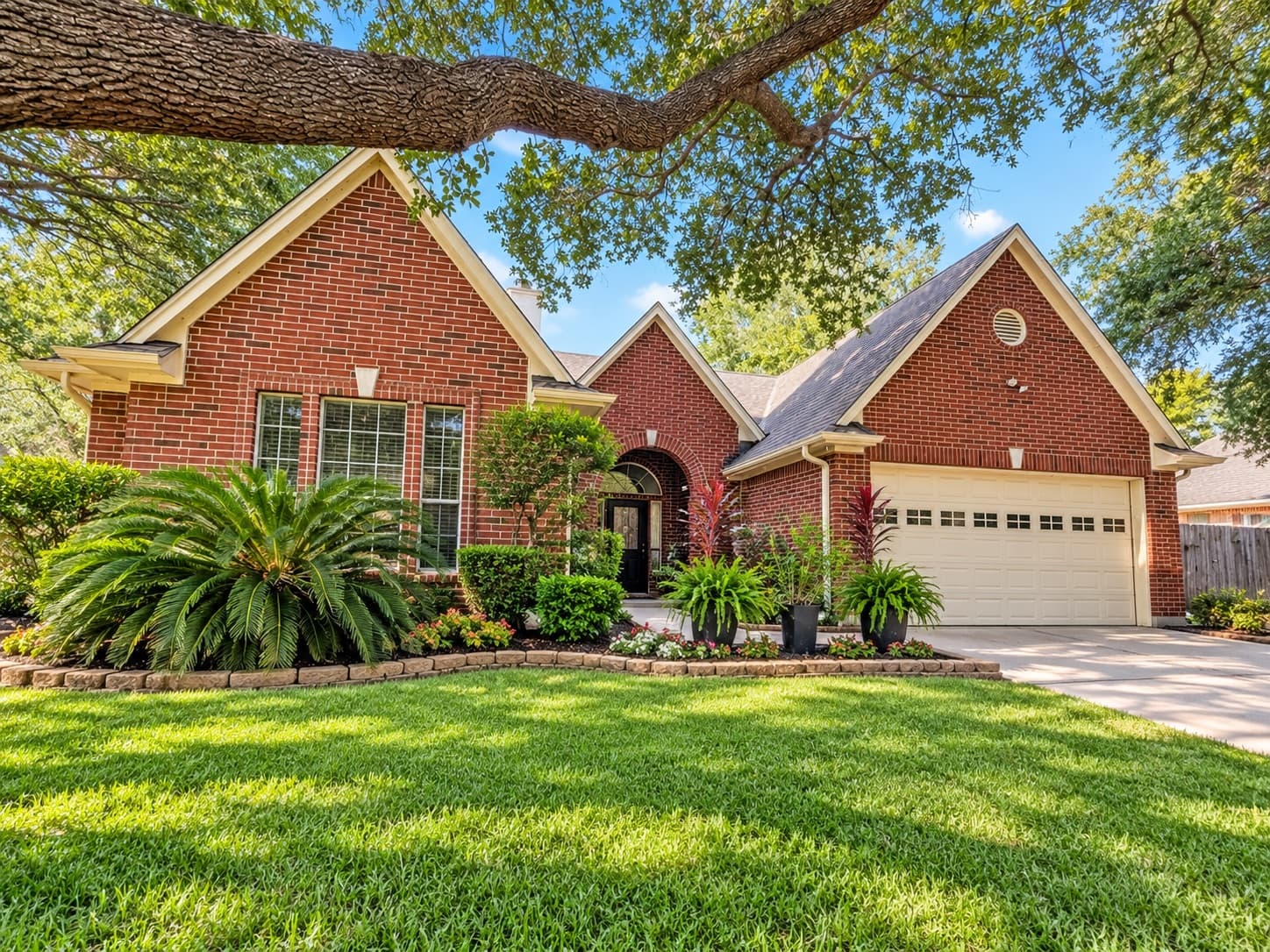 A brick home under a live oak, one of Gableway Realty's Houston-area listings